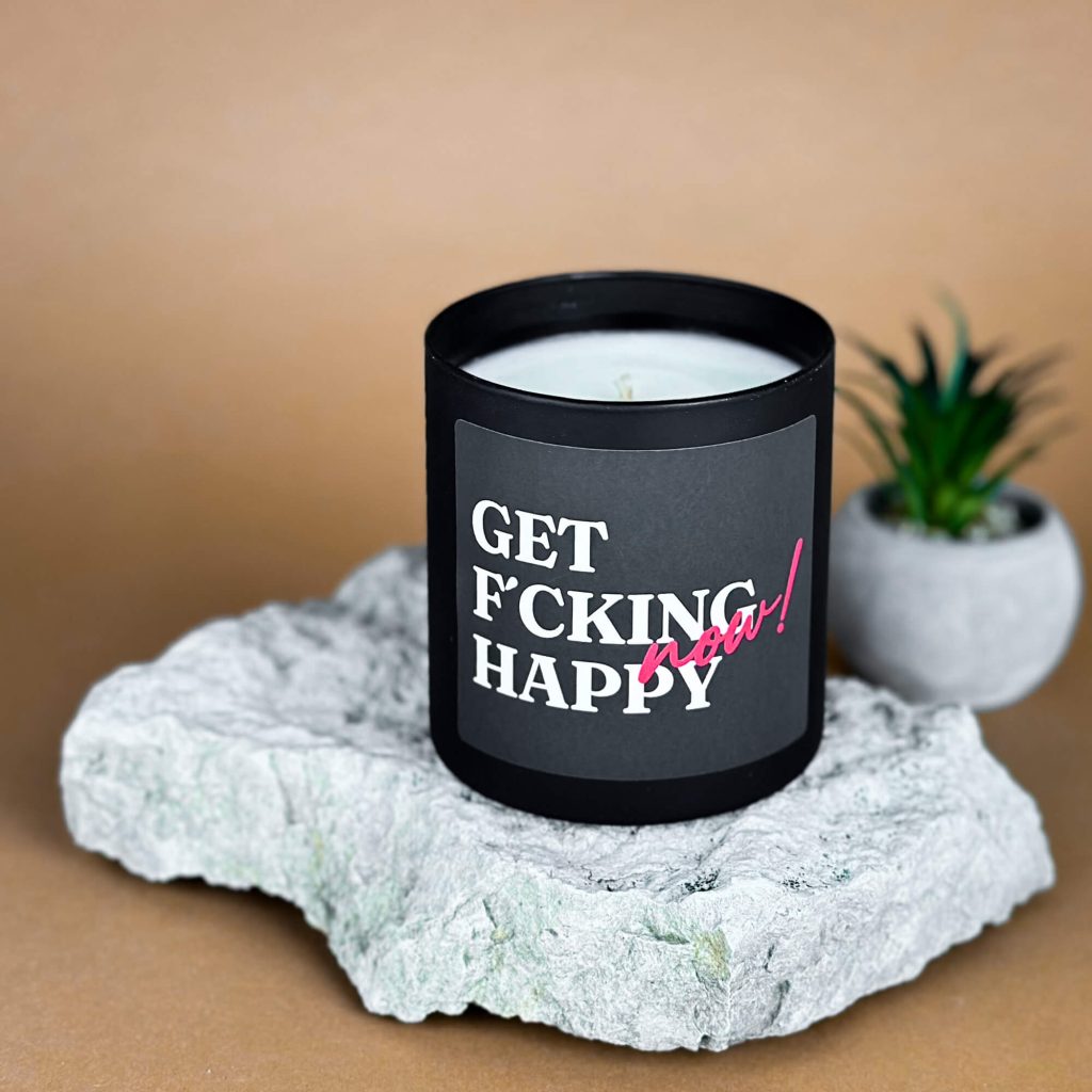Sojavahast lõhnaküünal “Get F’cking Happy Now!”. 280 grammi, põlemisaeg kuni 55h. Mustas klaaspurgis. Küünal toetab positiivset meeleolu ja aitab tuua oma päeva rohkem kergust.